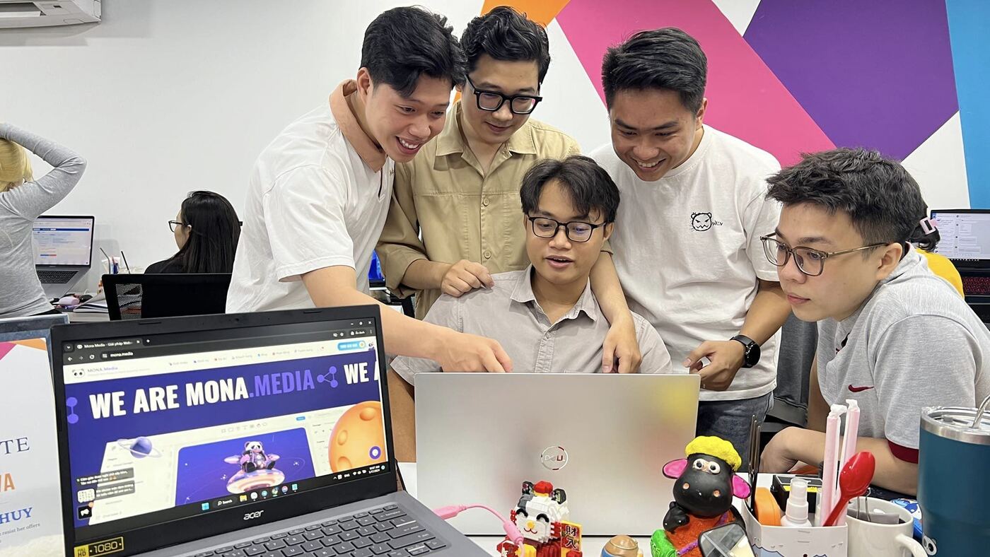 Nhóm thiết kế MONA cùng duyệt giao diện website trên laptop tại văn phòng